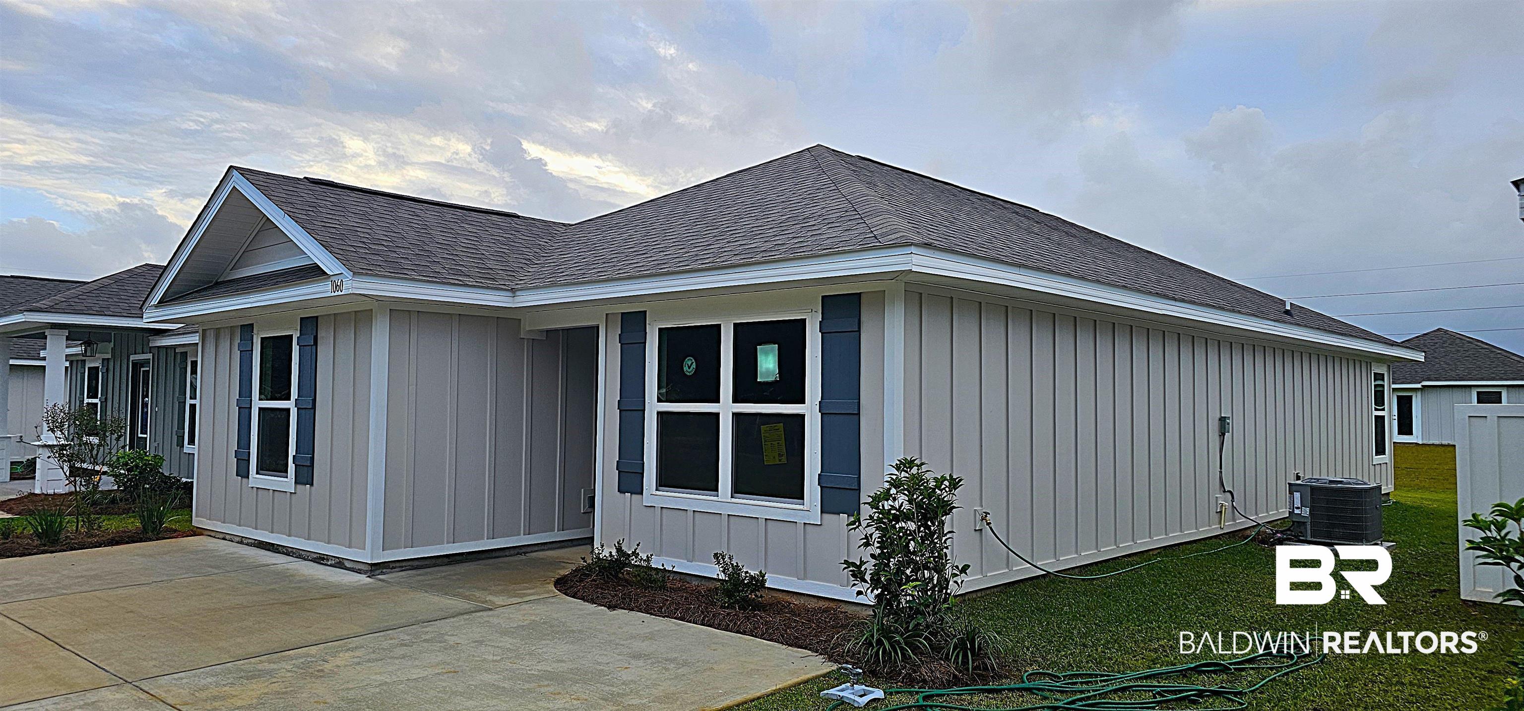 1060 South Bay Street Foley, AL 36535 - Photo 4 of 35 View of property exterior with a patio area, cooling unit, and a lawn