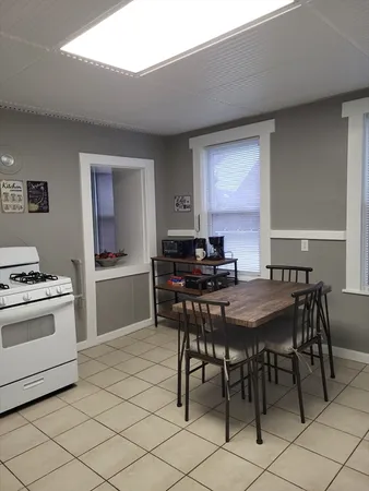a kitchen with a table chairs a stove and a refrigerator