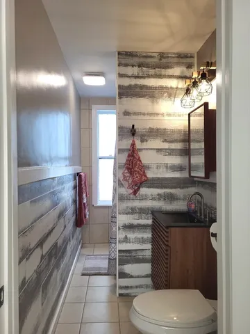 a bathroom with a walk in closet and wooden floor
