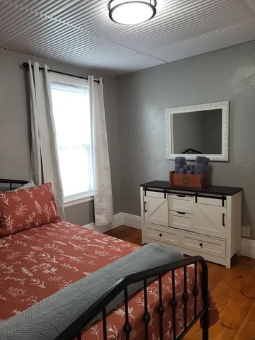 a bedroom with a bed and a flat tv screen