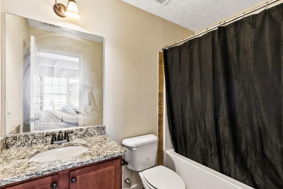 1946 Appaloosa Mill Circle Northeast Buford, GA 30519 - Photo 13 of 20 a bathroom with a granite countertop sink toilet and a mirror