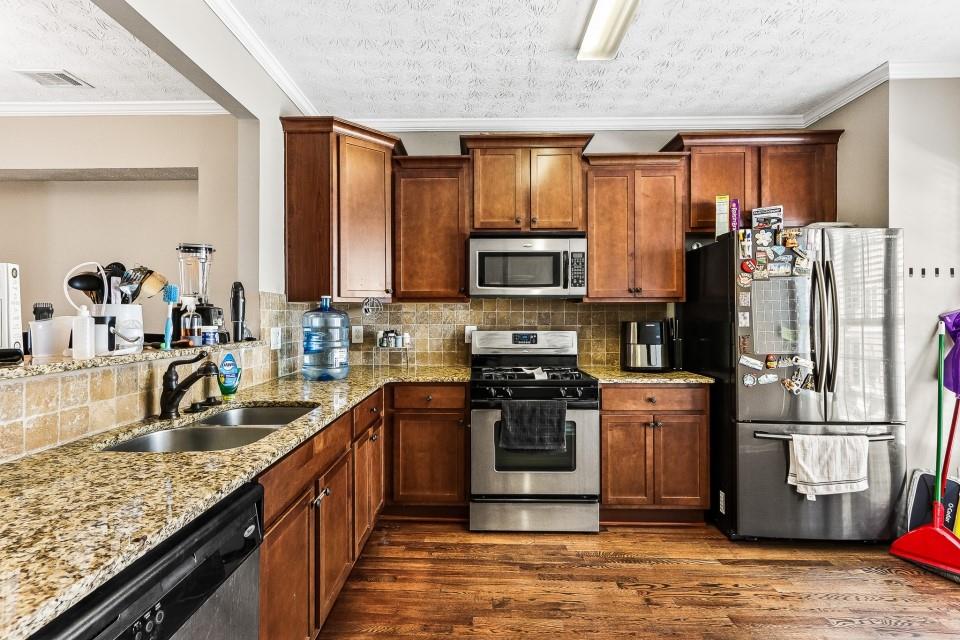 1946 Appaloosa Mill Circle Northeast Buford, GA 30519 - Photo 2 of 20 a kitchen with stainless steel appliances granite countertop a refrigerator stove microwave and sink
