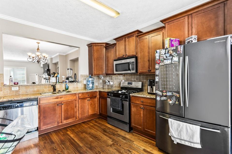 1946 Appaloosa Mill Circle Northeast Buford, GA 30519 - Photo 3 of 20 a kitchen with stainless steel appliances granite countertop a refrigerator stove and sink