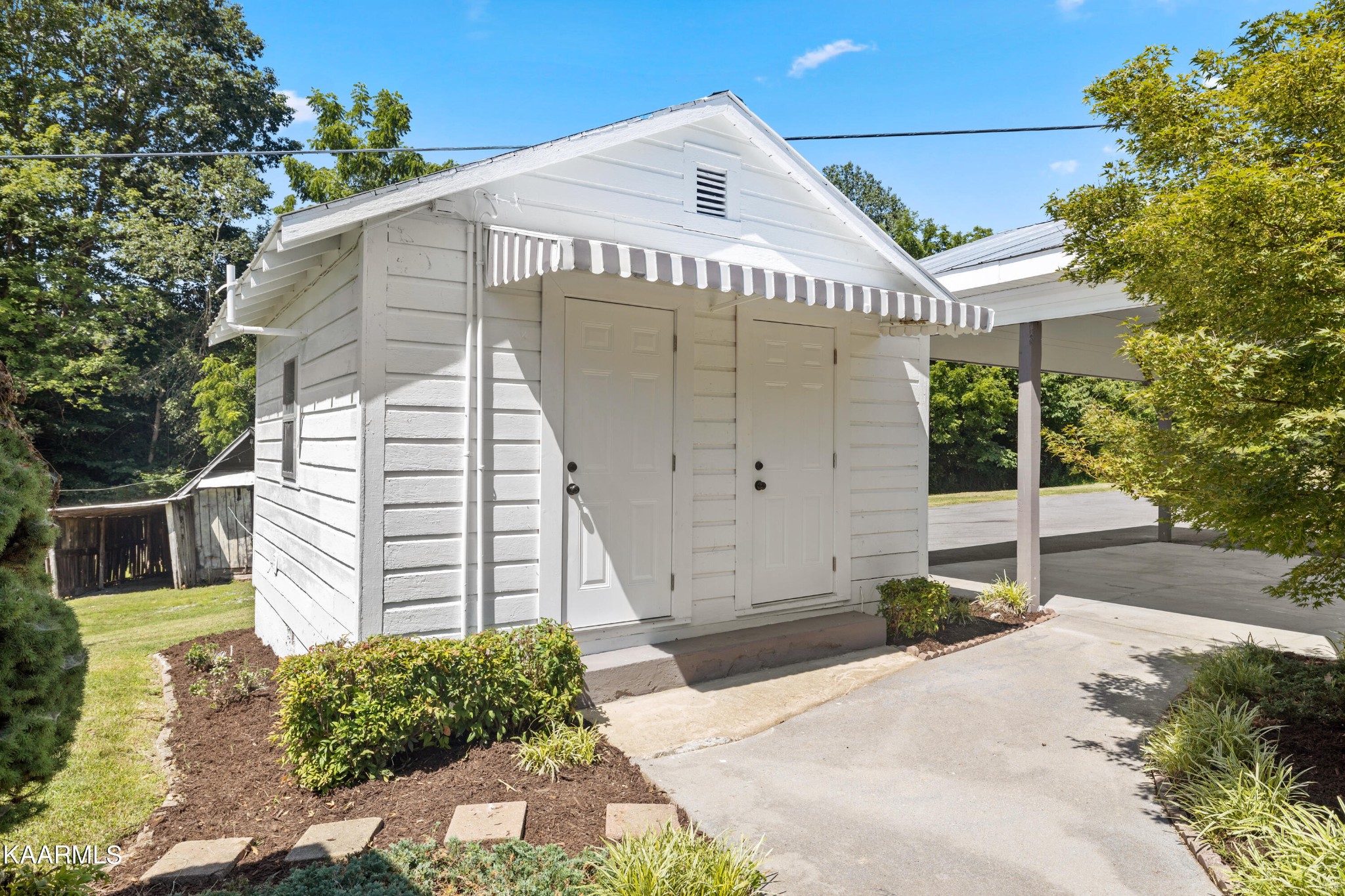 3044 Sims Road Sevierville, TN 37876 - Photo 26 of 34 a view of a white house with a yard and potted plants