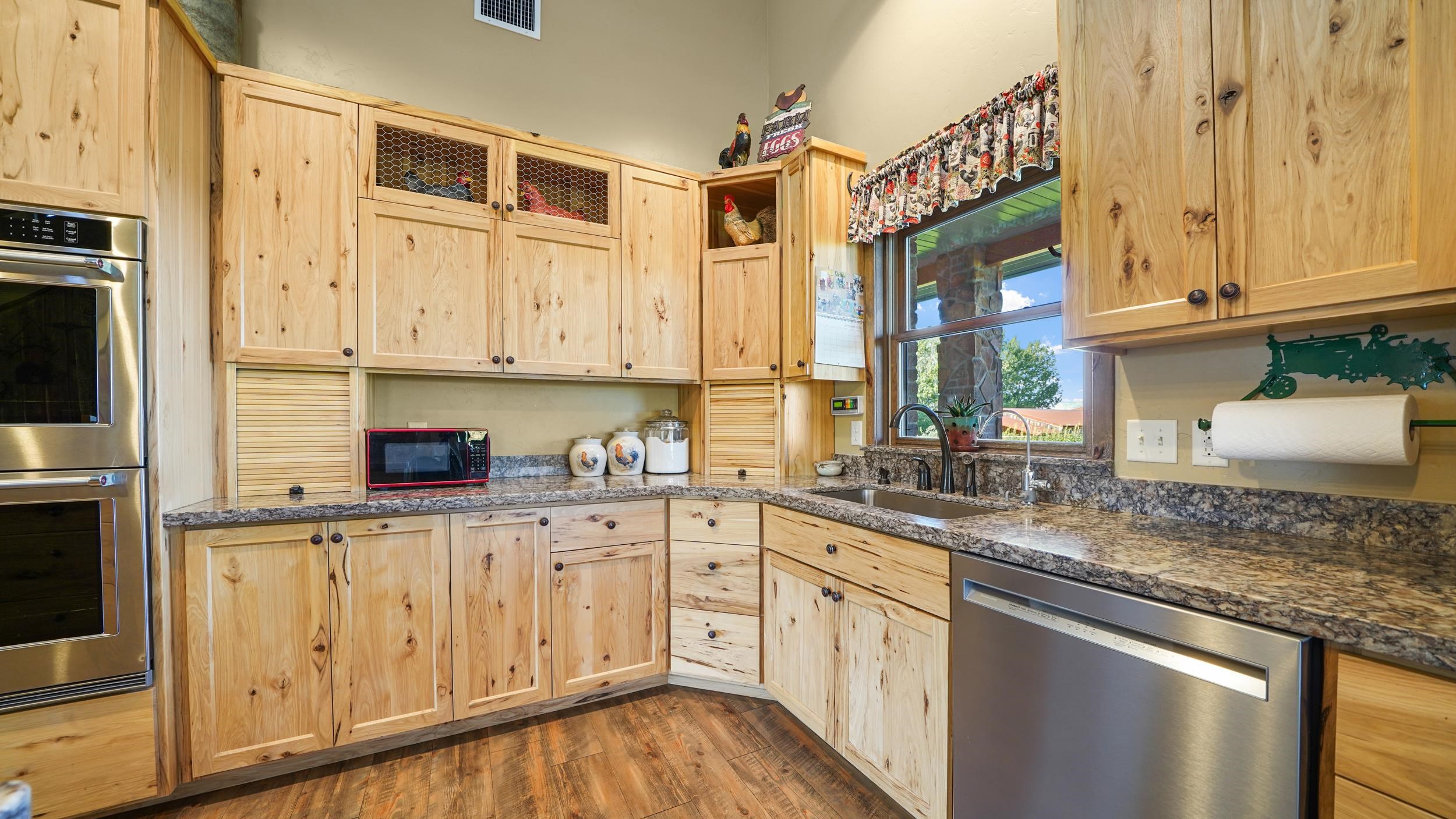 1029 25 Road Grand Junction, CO 81505 - Photo 20 of 42 a kitchen with stainless steel appliances granite countertop a sink and dishwasher with wooden floor