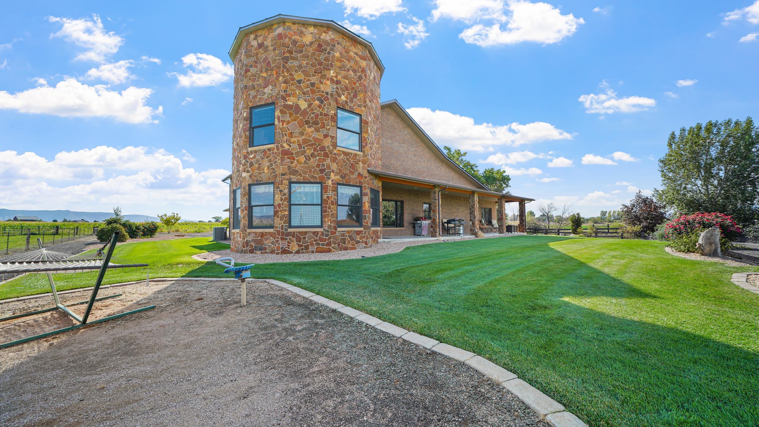 1029 25 Road Grand Junction, CO 81505 - Photo 39 of 42 a view of a brick house with a big yard and large trees