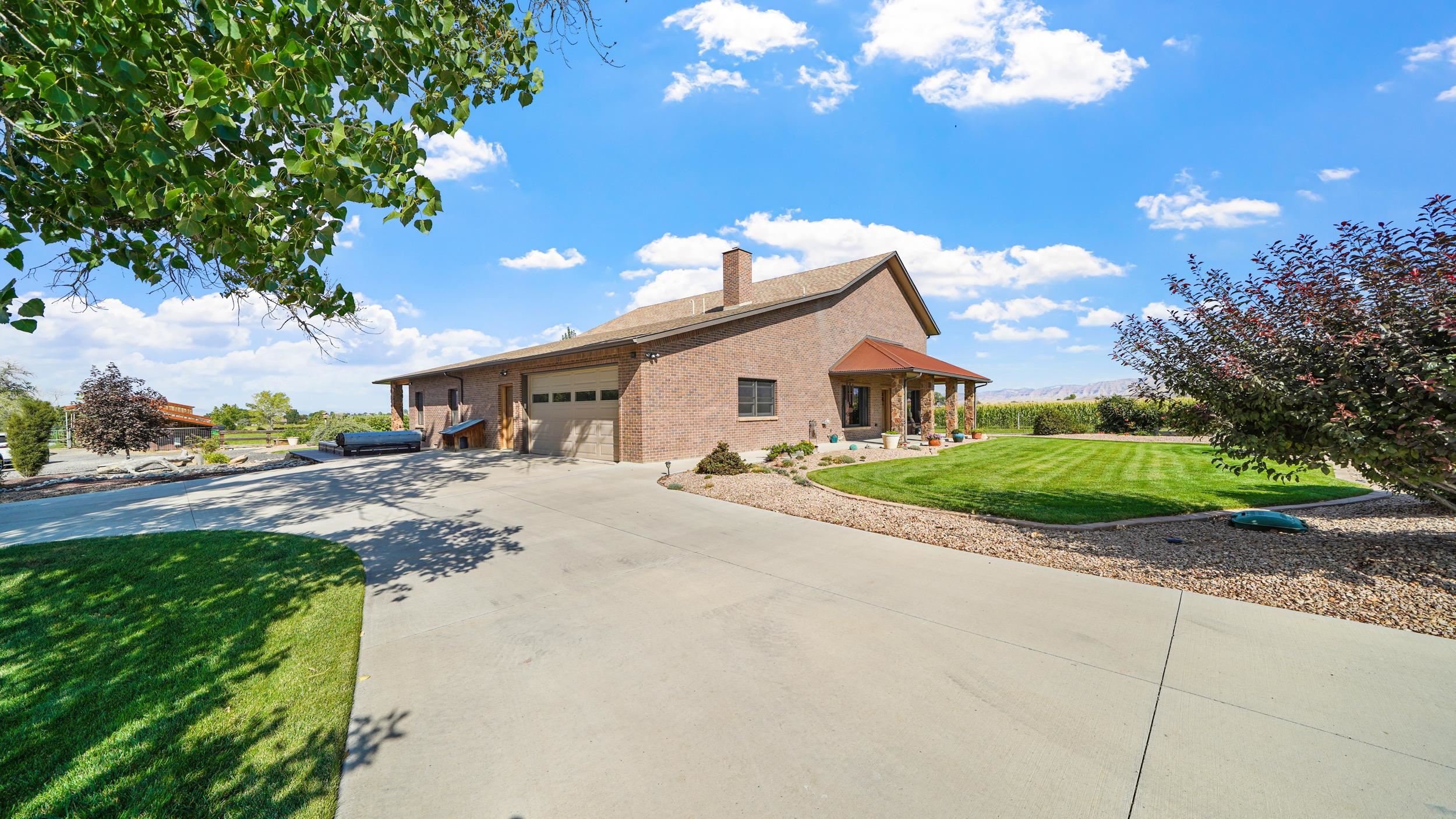 1029 25 Road Grand Junction, CO 81505 - Photo 7 of 41 a front view of a house with a yard and garage