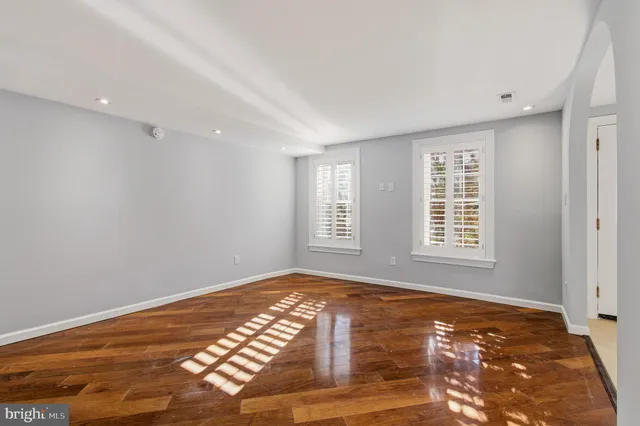 a view of an empty room with kitchen and a window