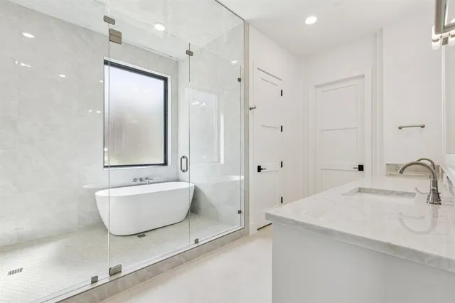 a bathroom with a sink and mirror with bathtub