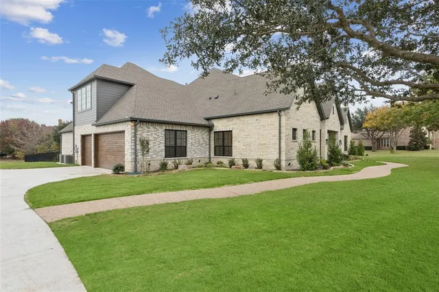 a view of a house next to a yard with big trees