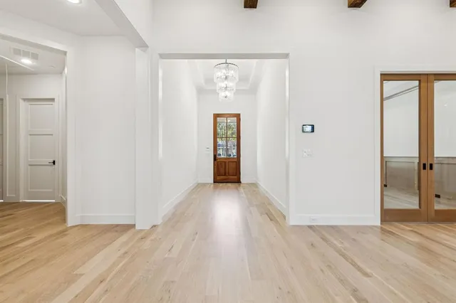 a view of a hallway with wooden floor and closet area