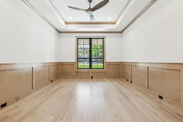a view of an empty room with a window and wooden floor