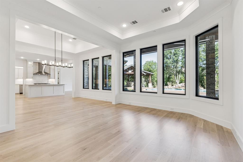 871 Beechwood Lane Fairview, TX 75069 - Photo 8 of 40 a view of an empty room with wooden floor and a window