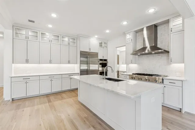 a kitchen with stainless steel appliances granite countertop a sink stove and refrigerator