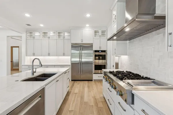a kitchen with stainless steel appliances granite countertop a sink stove and refrigerator