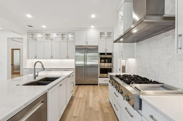 a kitchen with stainless steel appliances granite countertop a sink stove and refrigerator