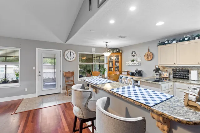 a kitchen with a table chairs and a wooden floor