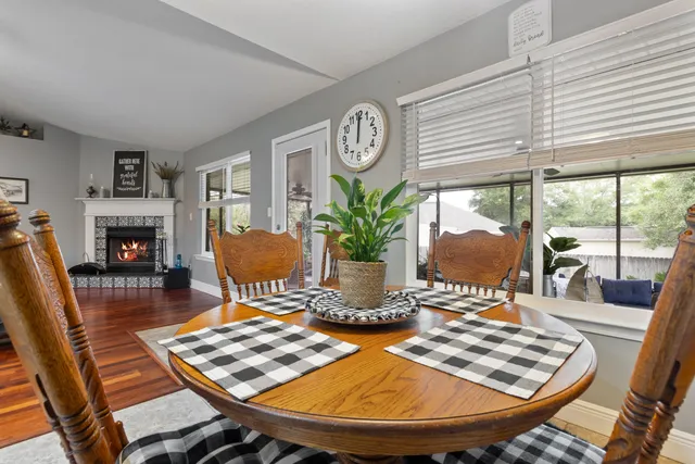 a dining room with furniture a fireplace and wooden floor