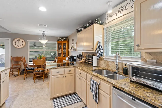 a kitchen with stainless steel appliances granite countertop a sink stove and cabinets
