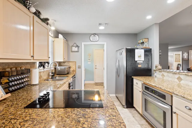 a kitchen with stainless steel appliances granite countertop a sink stove and refrigerator