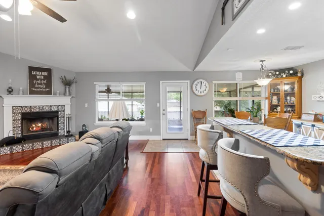 a living room with furniture a fireplace and wooden floor
