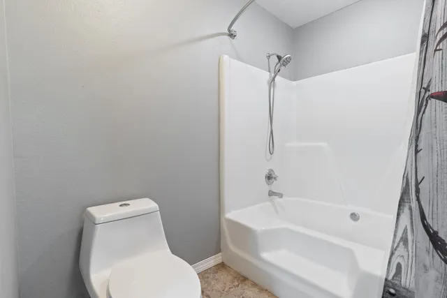a white toilet sitting next to a bath tub shower