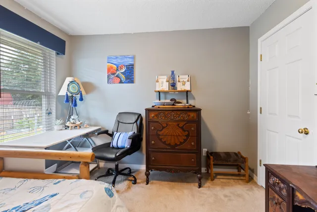 a view of a workspace with furniture and a window