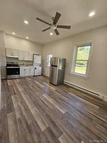 a open kitchen with kitchen island a stove a sink and a refrigerator