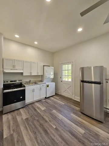 a kitchen with a refrigerator and a stove top oven