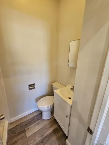 a white toilet sitting next to a white sink and vanity