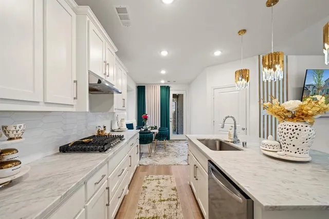 a kitchen with granite countertop a sink a stove and cabinets