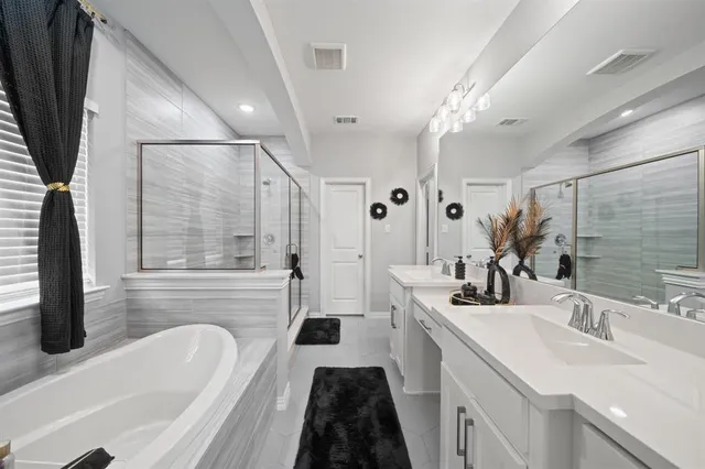 a bathroom with a sink a bathtub a mirror and vanity