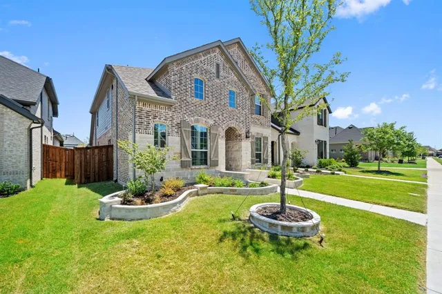 a front view of a house with a garden and fountain