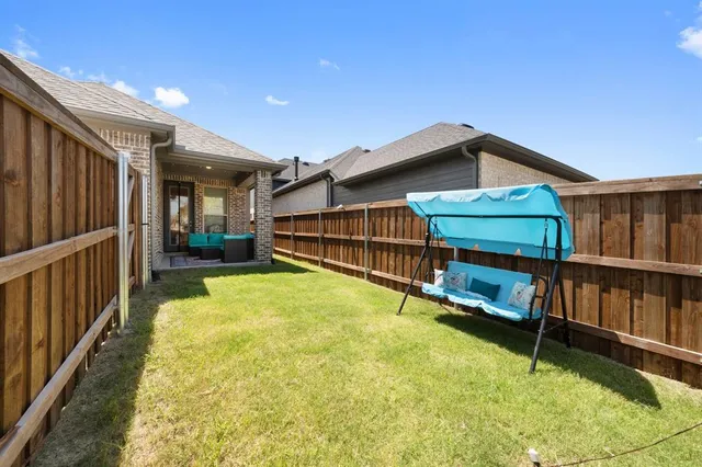 a view of a backyard with a small pool and wooden fence