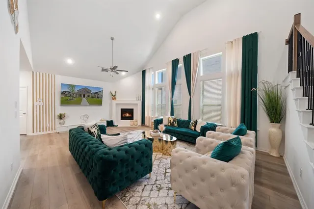a living room with fireplace furniture and a large window