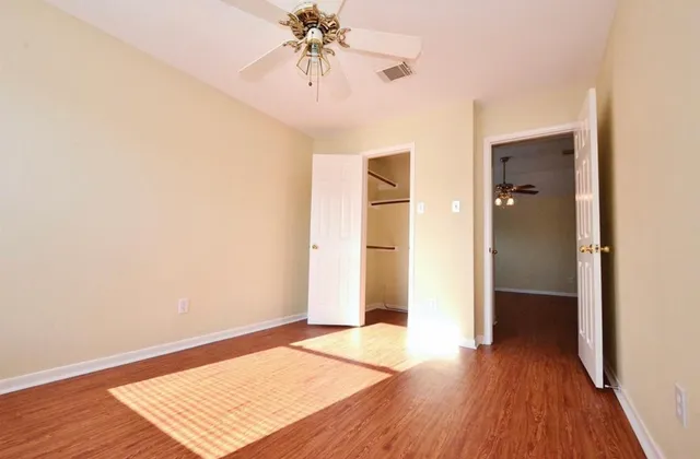 an empty room with wooden floor and closet