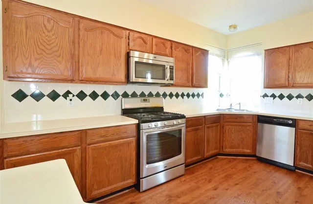 a kitchen with stainless steel appliances granite countertop a stove a sink and a microwave