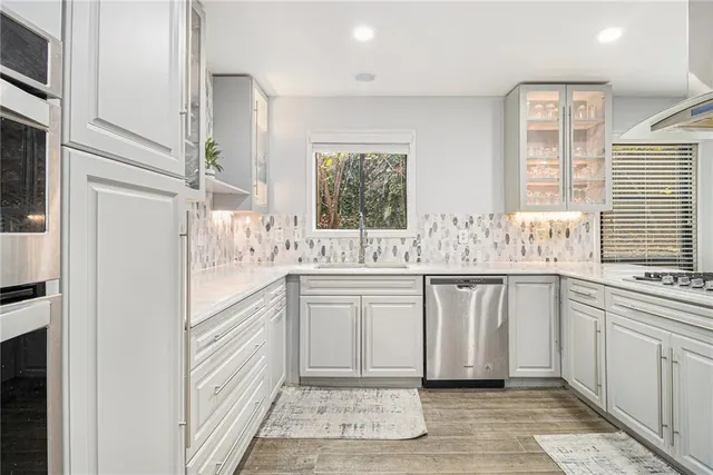 a kitchen with white cabinets and white appliances