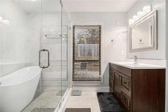 a bathroom with a sink a toilet a mirror and shower