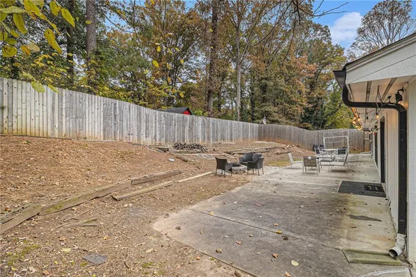 a view of a backyard with a table and chairs with wooden fence