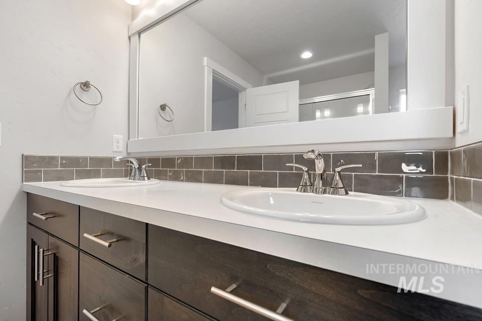 1340 Dawn Street Weiser, ID 83672 - Photo 17 of 32 Bathroom with double vanity, backsplash, and a shower stall