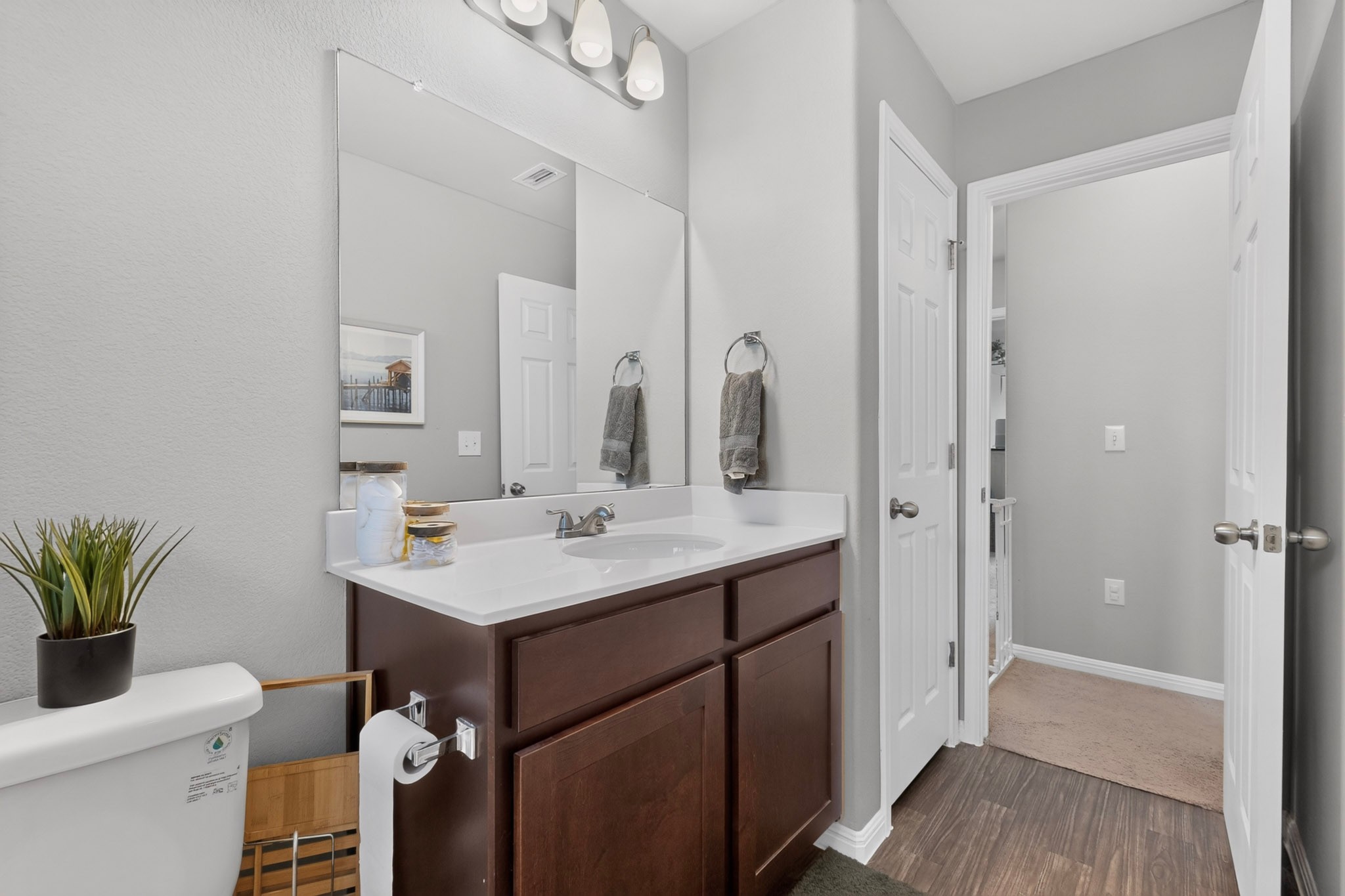 132 Wapiti Road Buda, TX 78610 - Photo 16 of 31 A well-lit bathroom features a single vanity with dark wood cabinetry and a large mirror.