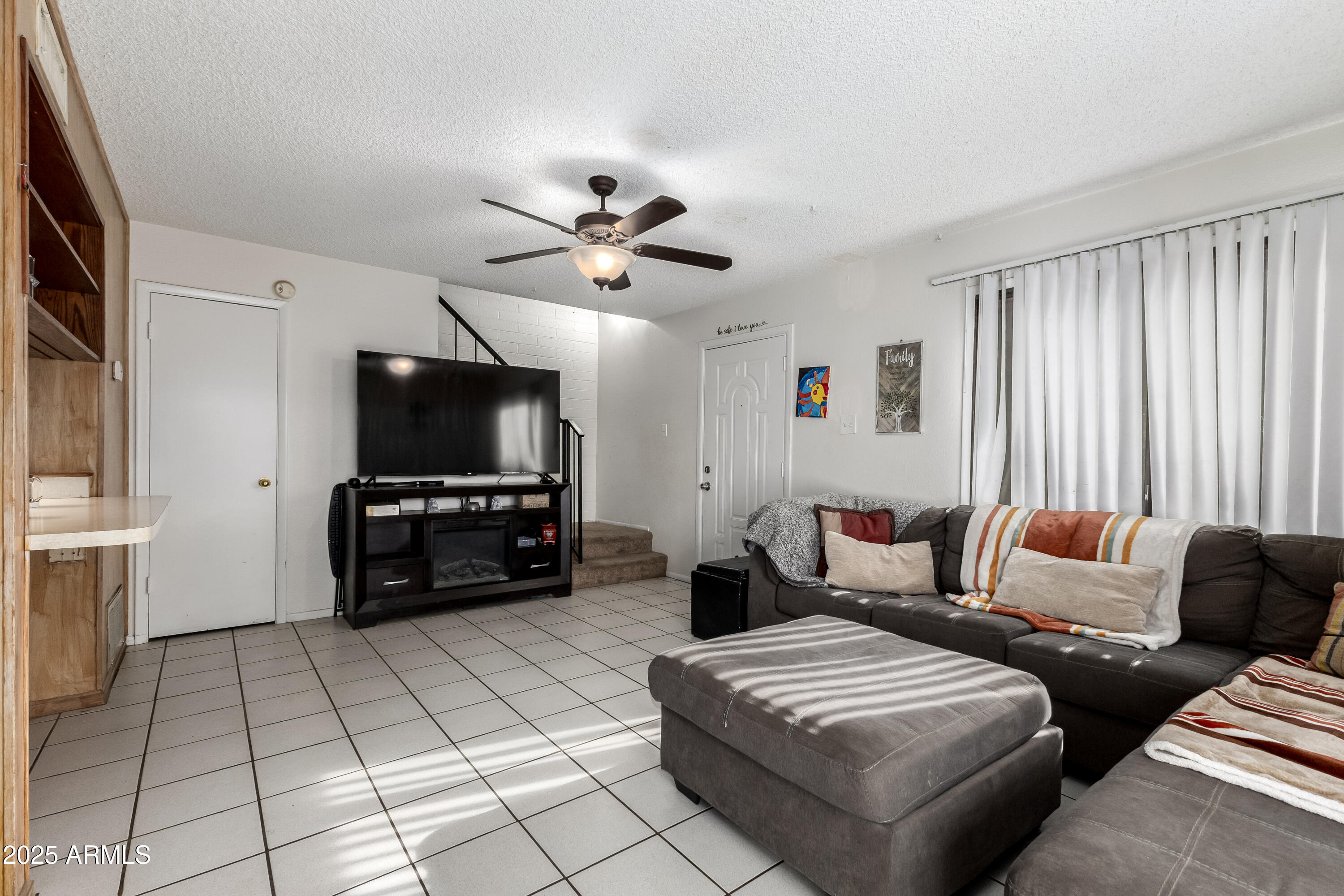 4107 West Wonderview Road Phoenix, AZ 85019 - Photo 4 of 13 a living room with furniture and a flat screen tv