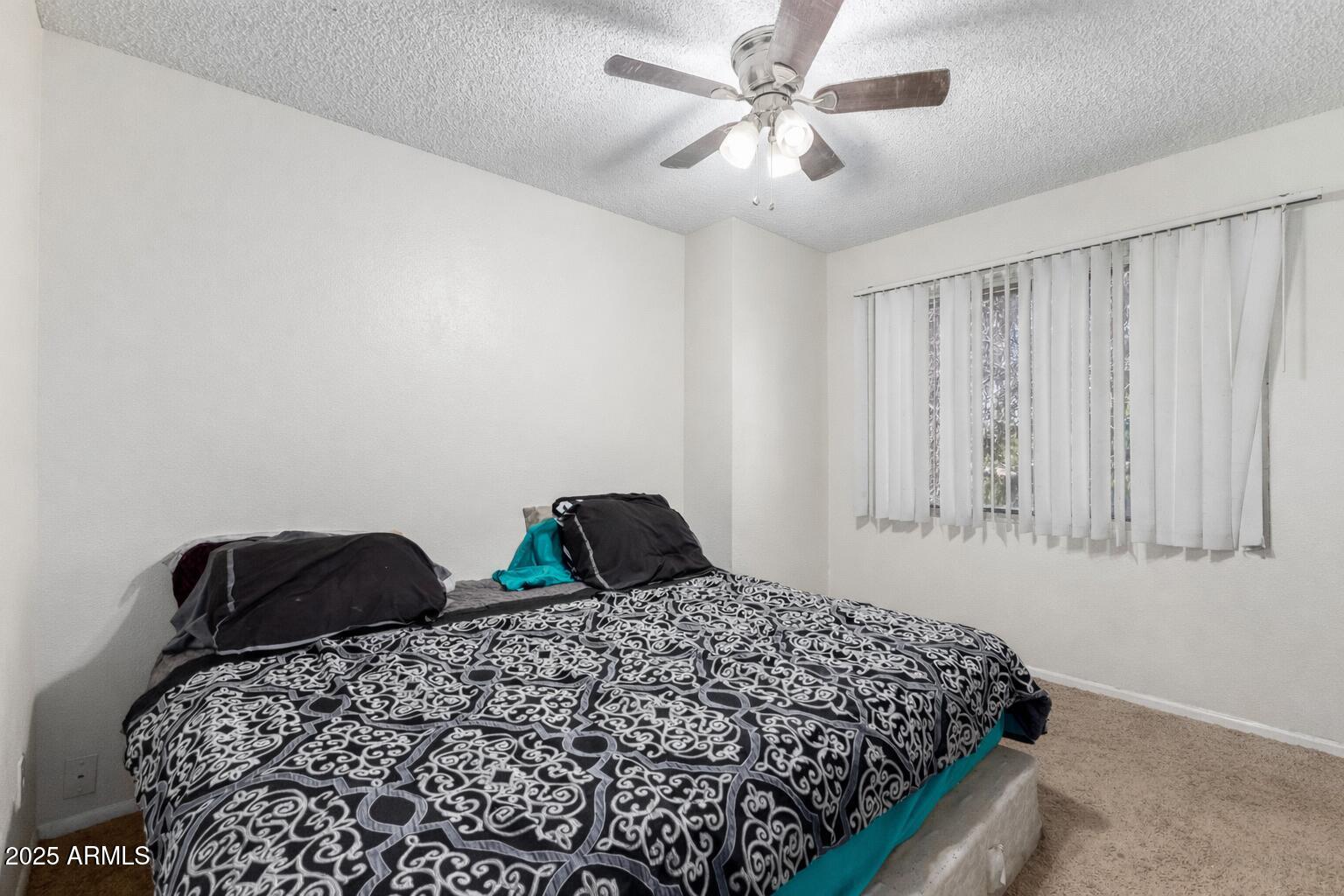 4107 West Wonderview Road Phoenix, AZ 85019 - Photo 7 of 13 a bedroom with bed and a window