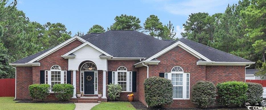 Ranch-style home with brick siding, concrete driveway, and roof with shingles