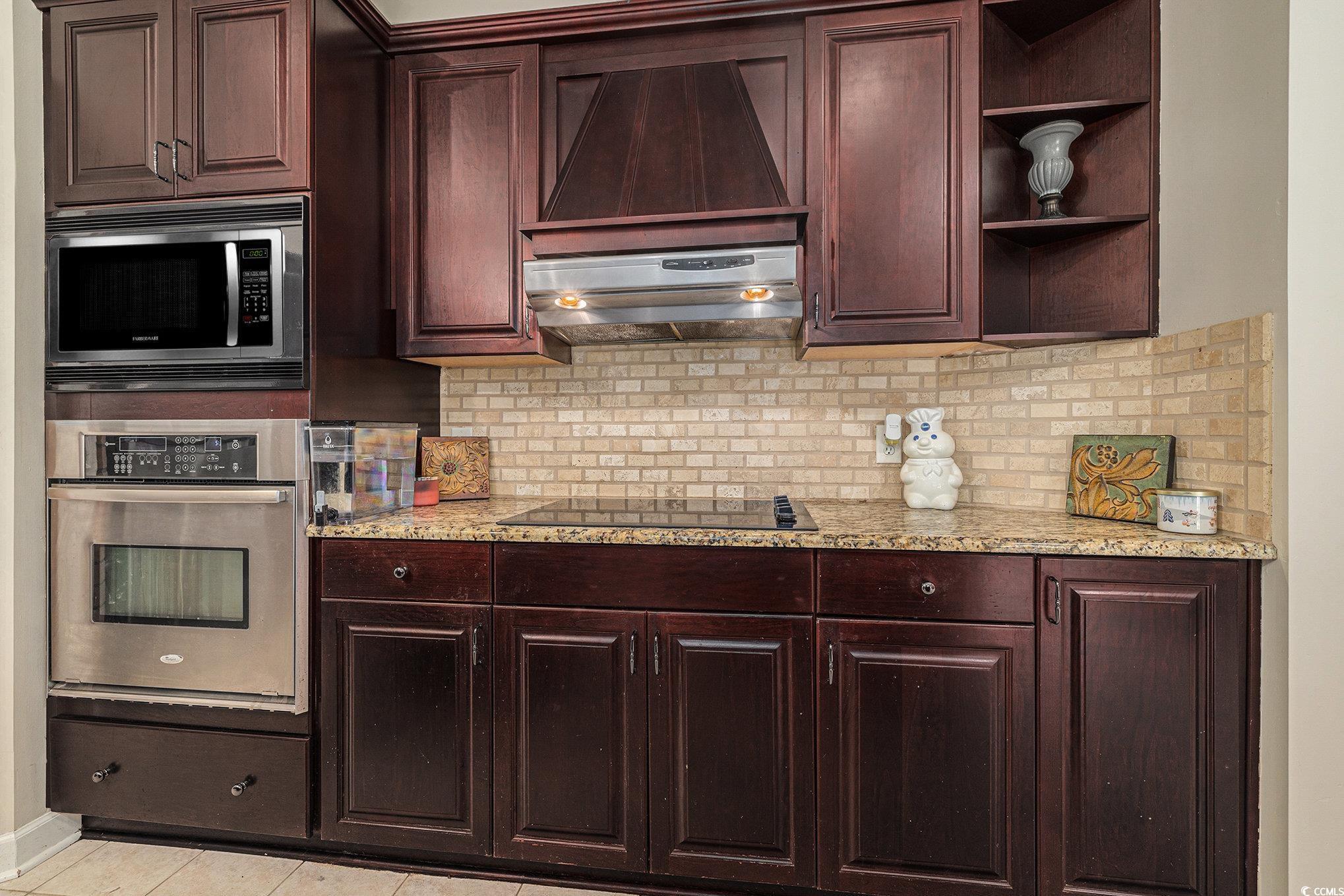 2425 Hunters Trail Myrtle Beach, SC 29588 - Photo 11 of 40 Kitchen featuring appliances with stainless steel finishes, decorative backsplash, open shelves, and exhaust hood