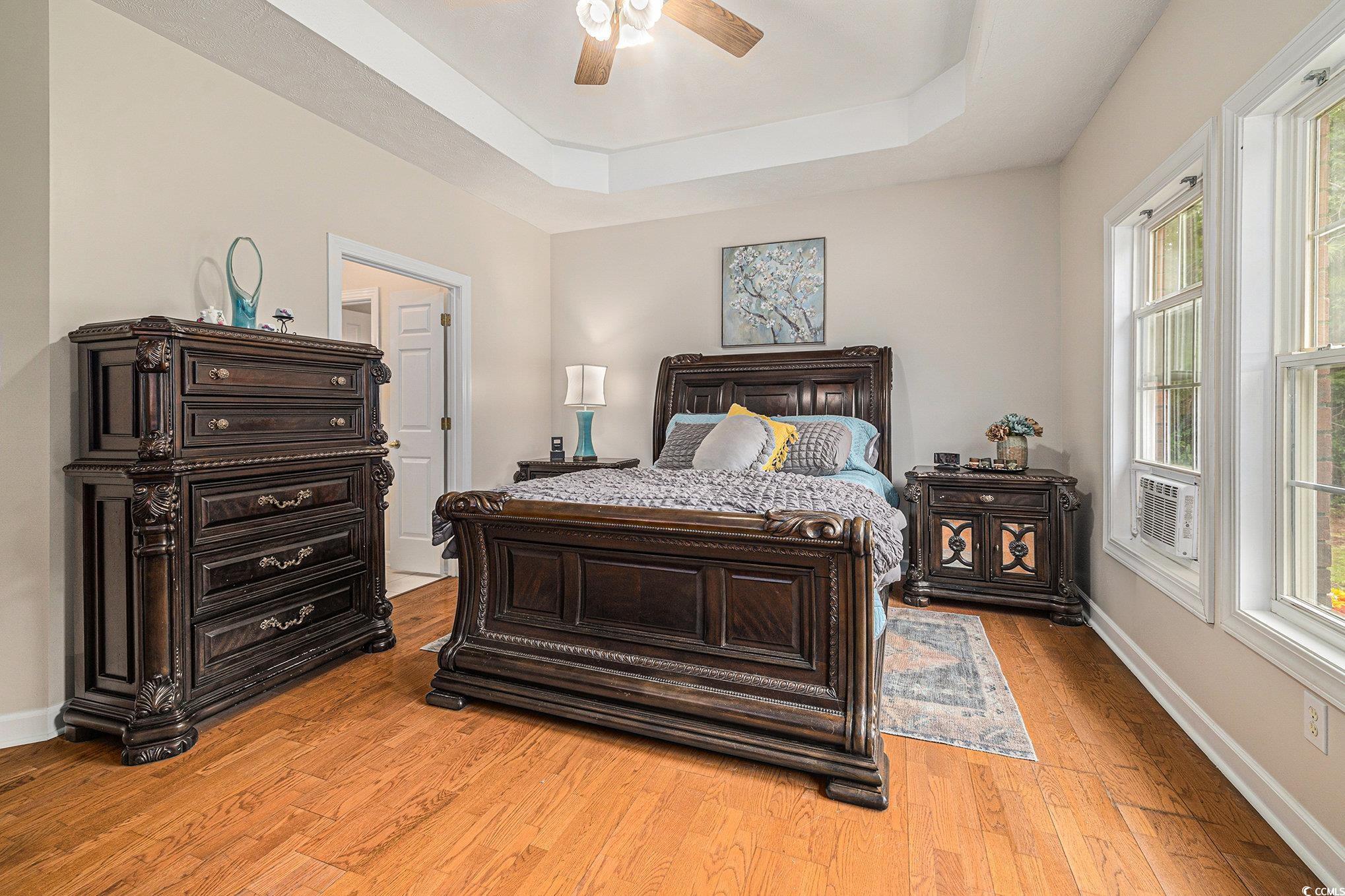 2425 Hunters Trail Myrtle Beach, SC 29588 - Photo 18 of 40 Bedroom with a tray ceiling, light wood finished floors, and ceiling fan
