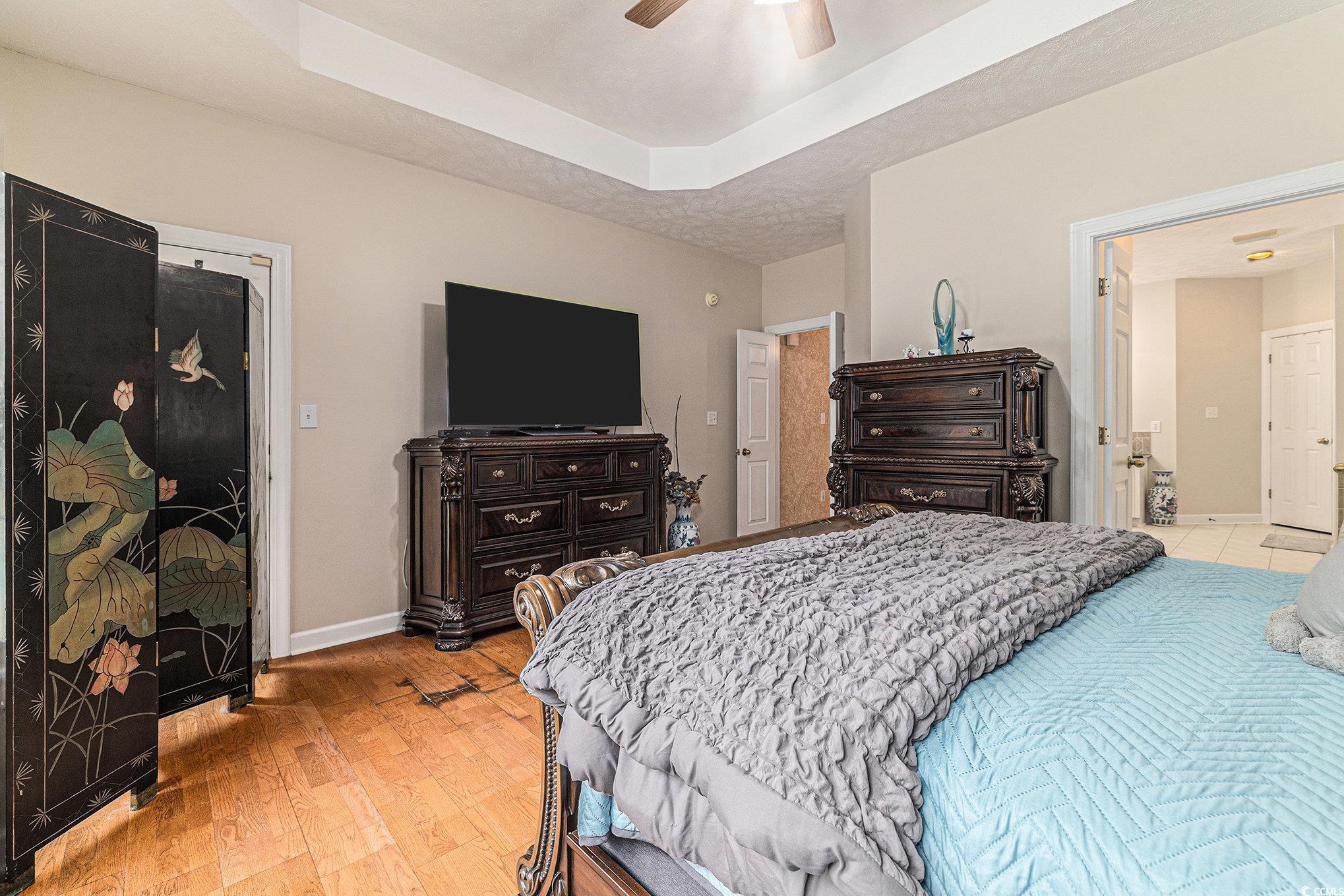 2425 Hunters Trail Myrtle Beach, SC 29588 - Photo 20 of 40 Bedroom featuring a raised ceiling, light wood-style flooring, and ceiling fan