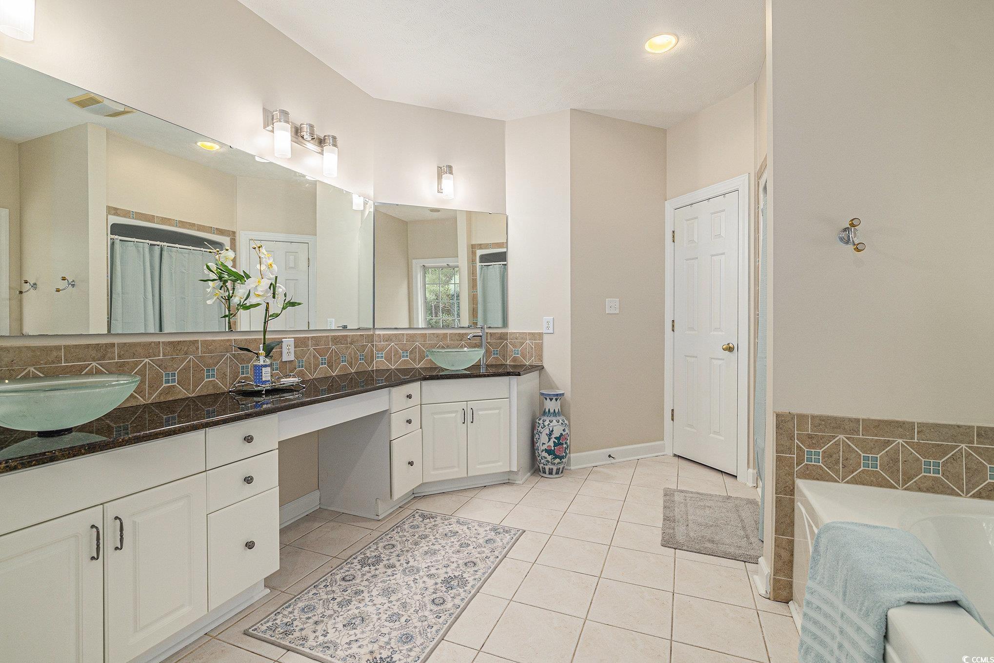 2425 Hunters Trail Myrtle Beach, SC 29588 - Photo 21 of 40 Bathroom with backsplash, double vanity, tile patterned flooring, a garden tub, and recessed lighting