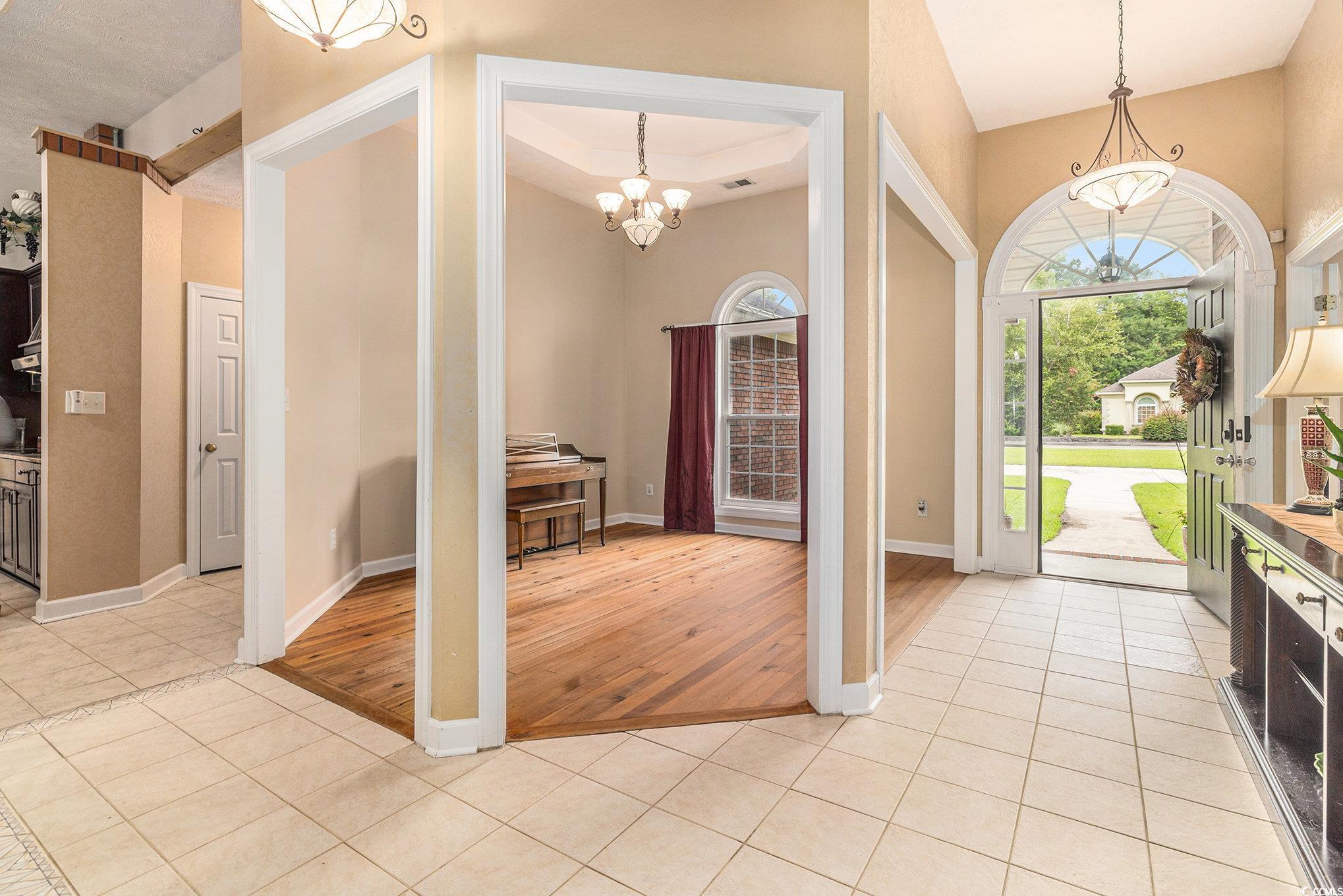 2425 Hunters Trail Myrtle Beach, SC 29588 - Photo 3 of 40 Entryway featuring light tile patterned floors, a chandelier, and a tray ceiling